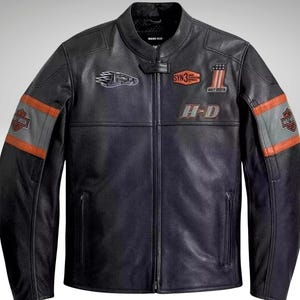 May include: Black leather motorcycle jacket with orange and gray accents on the sleeves. Features multiple patches with logos and the letters "H-D". The jacket has a classic collar and a front zipper.