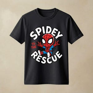 May include: A black short-sleeve t-shirt featuring a graphic of a cartoon Spider-Man character in a red and blue suit. The text "SPIDEY TO THE RESCUE" is printed in white and red around the character, who is making a hand gesture.