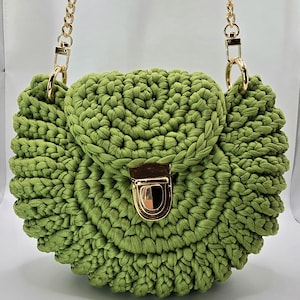 May include: A green crocheted handbag with a gold chain strap and a gold clasp.