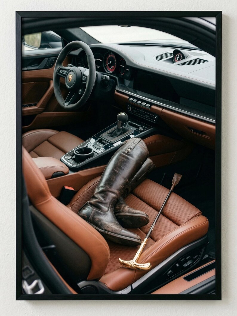 Puede incluir: Interior de un coche de lujo con asientos de cuero marr&oacute;n y un salpicadero negro. Un par de botas de montar de cuero marr&oacute;n y una fusta con mango dorado descansan en el asiento del conductor.