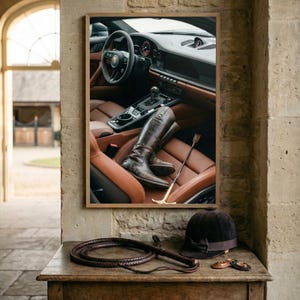 Puede incluir: Una fotograf&iacute;a enmarcada de un interior de coche con asientos de cuero marr&oacute;n y botas de montar. Un l&aacute;tigo, un casco de montar y una fusta est&aacute;n sobre una mesa de madera frente a la fotograf&iacute;a.