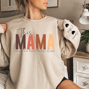 Custom This Mama Wears Her Heart On Her Sleeve Sweater, Personalized Mom Sweatshirt With Kids Names, Cute Momma Outfit, Mothers Day Gifts
