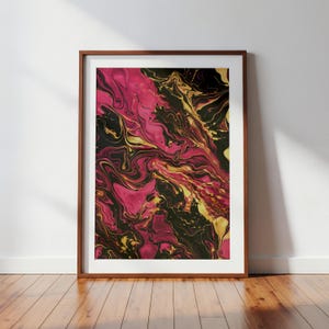 May include: Abstract art print in a wooden frame. The artwork features a swirling pattern of pink, black, and gold colors. The framed art is displayed on a wooden floor against a white wall.