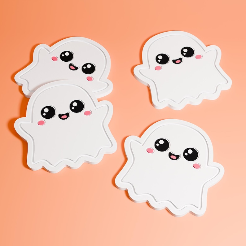 May include: Four white ghost-shaped decorations with black eyes, pink cheeks, and small black smiles. The ghosts have a wavy outline and are arranged on a peach-coloured background. These cute, cartoonish ghosts are perfect for Halloween.