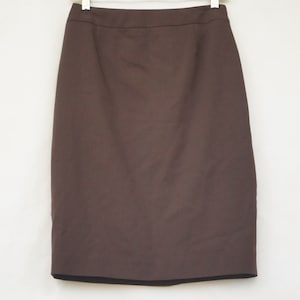 May include: A brown pencil skirt with a straight cut and a simple design.