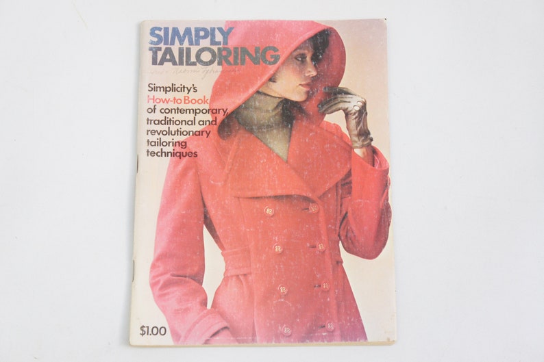 May include: A vintage book titled "Simply Tailoring" with a red coat and a woman wearing it on the cover. The book is a how-to guide for contemporary, traditional, and revolutionary tailoring techniques.