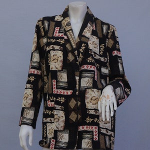 May include: A long-sleeved black blazer with a multi-colored geometric pattern. The pattern features beige, brown, red, and white geometric shapes and designs.