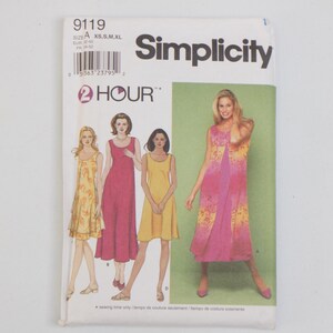 May include: A Simplicity sewing pattern envelope, number 9119, featuring illustrations of sleeveless dresses in various lengths and colours, including yellow, pink, and floral patterns. The text includes 2 HOUR, Simplicity, and size range XS, S, M, XL.