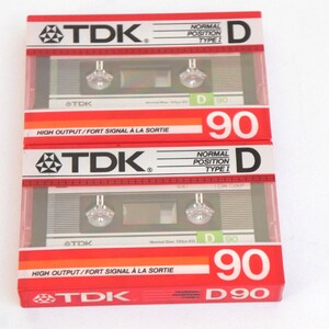 Puede incluir: Tres cintas de casete rojas y plateadas etiquetadas "TDK" con el texto "Posici&oacute;n normal Tipo I" y "D 90" en la parte delantera. Las cintas est&aacute;n etiquetadas "High Output/Fort Signal &agrave; la Sortie" en la parte inferior.
