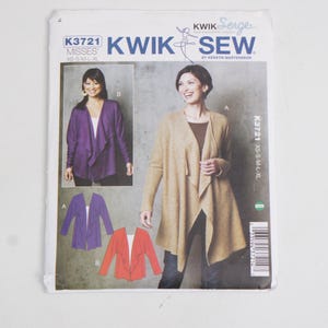 Può includere: Una busta per cartamodello Kwik Sew K3721 per un cardigan. La parte anteriore mostra un cardigan color marrone chiaro e uno viola con un design drappeggiato sul davanti. Il testo include Kwik Sew, K3721 e le taglie XS, S, M, L, XL.
