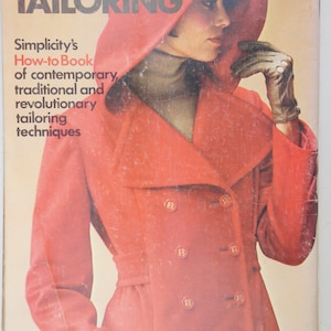May include: A vintage book titled "Simply Tailoring" with a red cover featuring a woman wearing a red coat with a hood. The book is a Simplicity How-to Book of contemporary, traditional and revolutionary tailoring techniques.