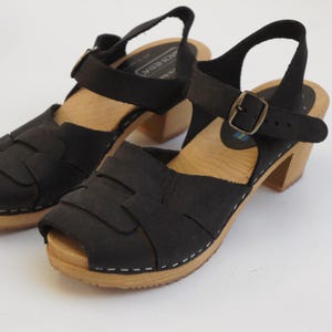 May include: A white ceramic mug with a black handle and the text "But First, Coffee" in a black, handwritten-style font. The mug is likely 11-15 ounces in size, perfect for a morning beverage.