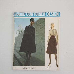 Może przedstawiać: Vintage wzór szycia Vogue Couturier Design. Okładka przedstawia kobietę w czarnej pelerynie i drugą w kostiumie ze spódnicą. Tekst "VOGUE COUTURIER DESIGN" znajduje się na górze. Numer wzoru 2497.