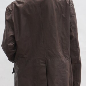 May include: A brown leather blazer with a classic design. The jacket features a notched lapel, two-button closure, and a single vent in the back. The sleeves have buttoned cuffs. The blazer is displayed on a mannequin.