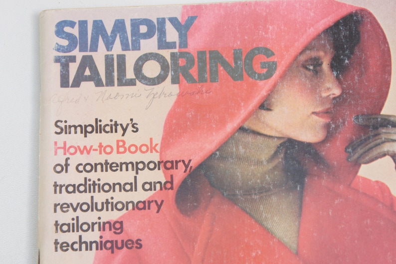May include: A book cover with the title "SIMPLY TAILORING" in bold black letters. The cover features a woman wearing a red hooded jacket and a turtleneck sweater. The text below the title reads "Simplicity's How-to Book of contemporary, traditional and revolutionary tailoring techniques."