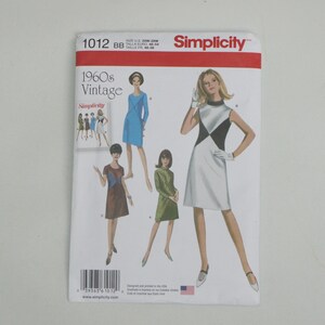 May include: Simplicity sewing pattern featuring vintage 1960s dress designs. The pattern includes illustrations of dresses in various styles and colors, including blue, green, and a black and white color block dress. The pattern number is 1012.
