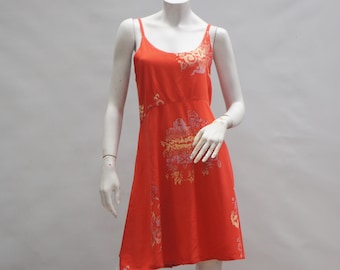 May include: A sleeveless, orange dress with a floral print. The dress has a scoop neck and a flowy skirt.