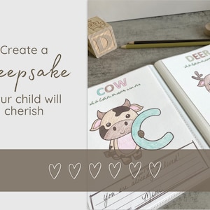 May include: A personalized keepsake book with the text "Create a Keepsake your child will cherish." The book features illustrations of a cow and a deer, with the letters "C" and "D" in a colorful design. A wooden block and pencils are also visible.