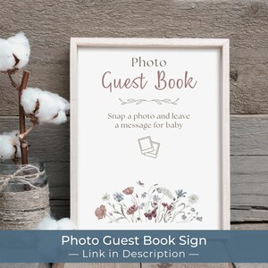 Puede incluir: Un letrero enmarcado con el texto "Photo Guest Book" en una fuente suave y elegante. El letrero incluye el texto "Snap a photo and leave a message for baby" y una ilustraci&oacute;n floral. Una rama de algod&oacute;n en un tarro est&aacute; a la izquierda.