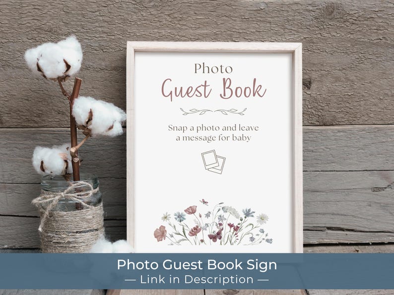 Puede incluir: Un letrero enmarcado con el texto "Photo Guest Book" en una fuente suave y elegante. El letrero incluye el texto "Snap a photo and leave a message for baby" y una ilustraci&oacute;n floral. Una rama de algod&oacute;n en un tarro est&aacute; a la izquierda.