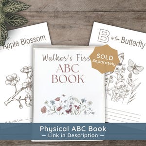 A mockup of a physical, spiral-bound "ABC Book" with a custom name "Walker’s First." A "Sold Separately" badge indicates this is a different listing from the digital download.
