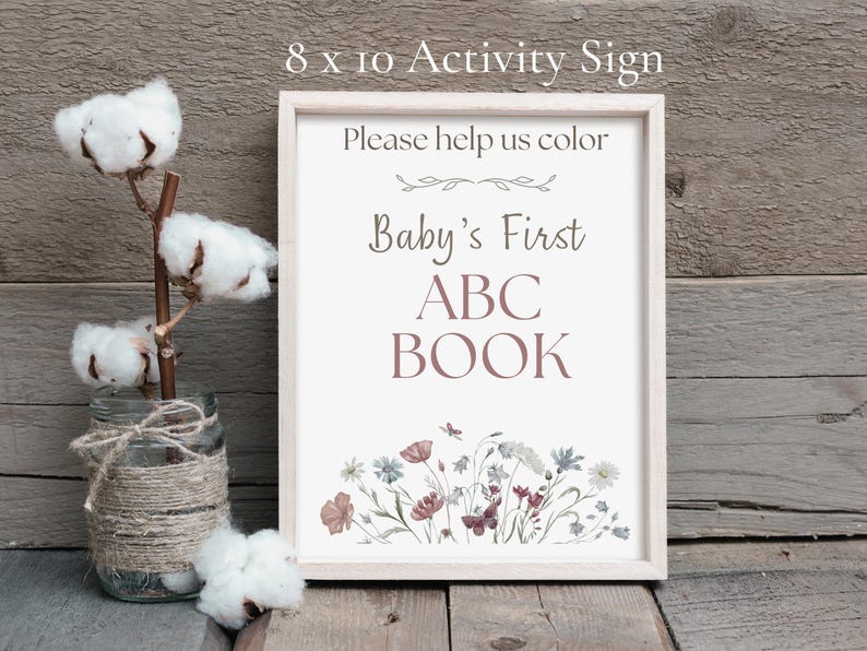 An 8x10 inch framed "Baby’s First ABC Book" activity sign that says "Please help us color." It is styled next to a glass jar with cotton stems on a rustic wooden background.