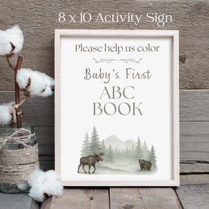 Rustic woodland ABC coloring book guest book alternative for baby shower, physical book with moose and mountain sketch illustrations, 26 A–Z pages for guests to color and sign, creating a heartfelt baby keepsake.