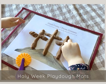 Pode incluir: Uma criança usa massa de modelar marrom para criar três cruzes em um tapete de papel branco com as palavras "Good Friday | Three Crosses" impressas nele. O tapete faz parte de um conjunto de tapetes de massa de modelar para a Semana Santa.