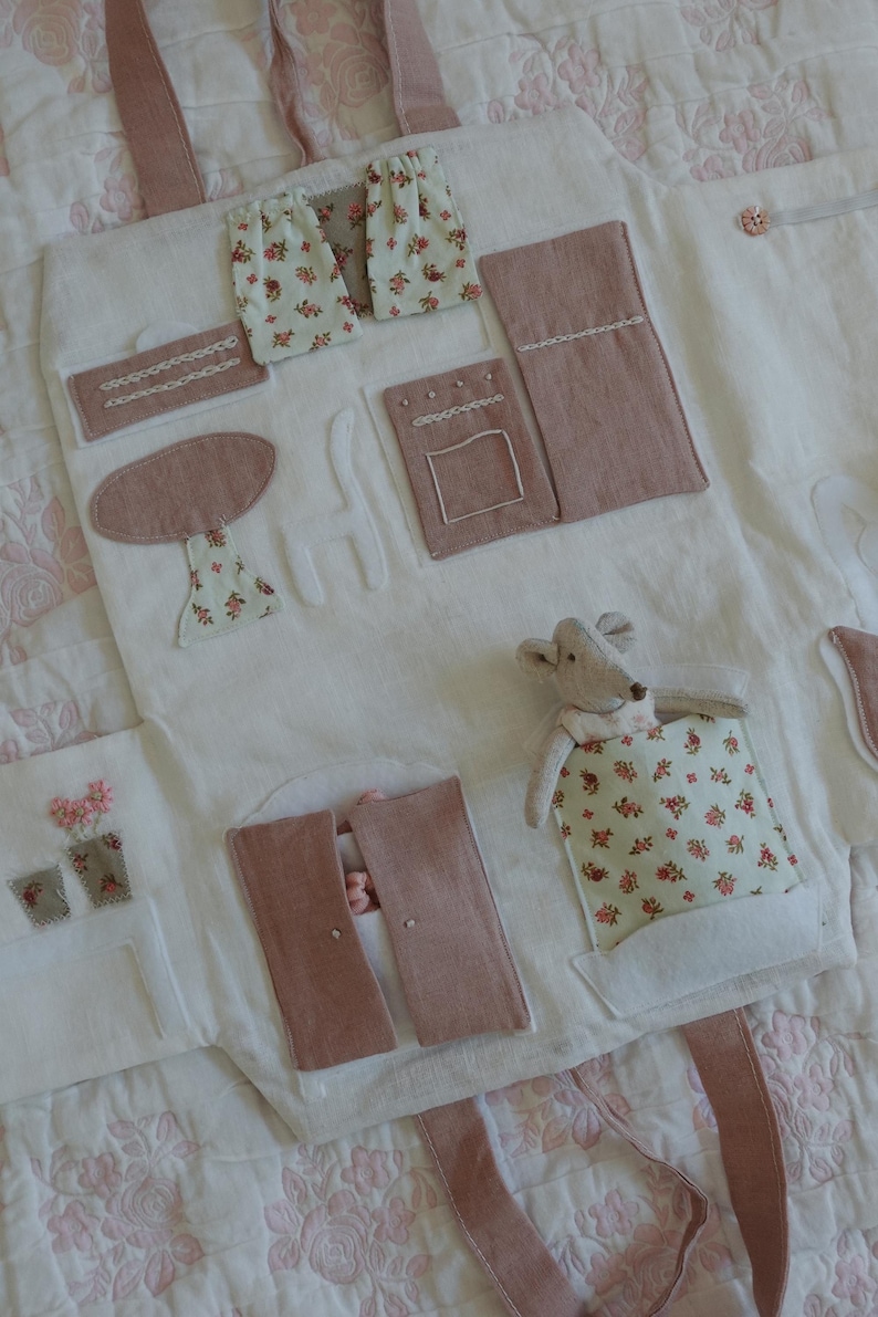 Puede incluir: Un juguete de tela blanca con detalles rosas y estampados florales. Incluye una mesa, cortinas y un rat&oacute;n de juguete. El juguete tiene un asa y est&aacute; dise&ntilde;ado para ni&ntilde;os.