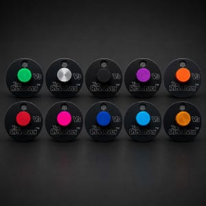 May include: Ten circular black metal devices labeled The Revolver V3, each featuring a small circular button in a different color: green, silver, black, purple, orange, red, pink, blue, light blue, and yellow-orange, arranged in two rows.