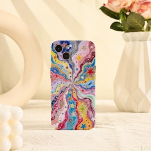 Puede incluir: Una funda de teléfono colorida con un diseño abstracto vibrante con líneas y estrellas radiantes en tonos de azul, rosa, amarillo y verde. La funda tiene un acabado brillante y un recorte para la cámara.