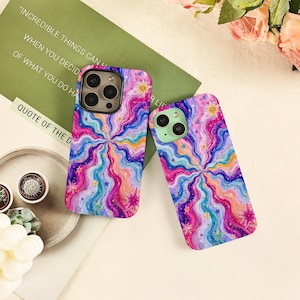 May include: Two smartphone cases featuring a vibrant, multi-colored wavy pattern in shades of pink, blue, purple, and orange. The design includes scattered small star shapes and larger, multi-pointed star icons throughout the swirling, psychedelic-inspired graphic print.