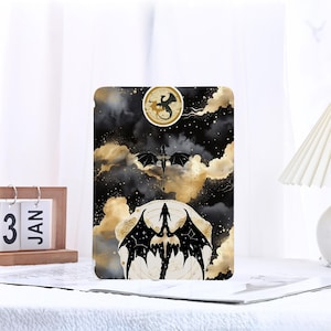 Op de afbeelding: Zwart en gouden drakenontwerp op een zwarte achtergrond met witte wolken. Het ontwerp is op een tablethoes.