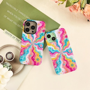 May include: Two rectangular phone cases featuring a vibrant, multi-colored wavy pattern in shades of pink, yellow, and blue. The design is accented with various star shapes in yellow, pink, and blue, creating a dynamic, swirling visual effect.