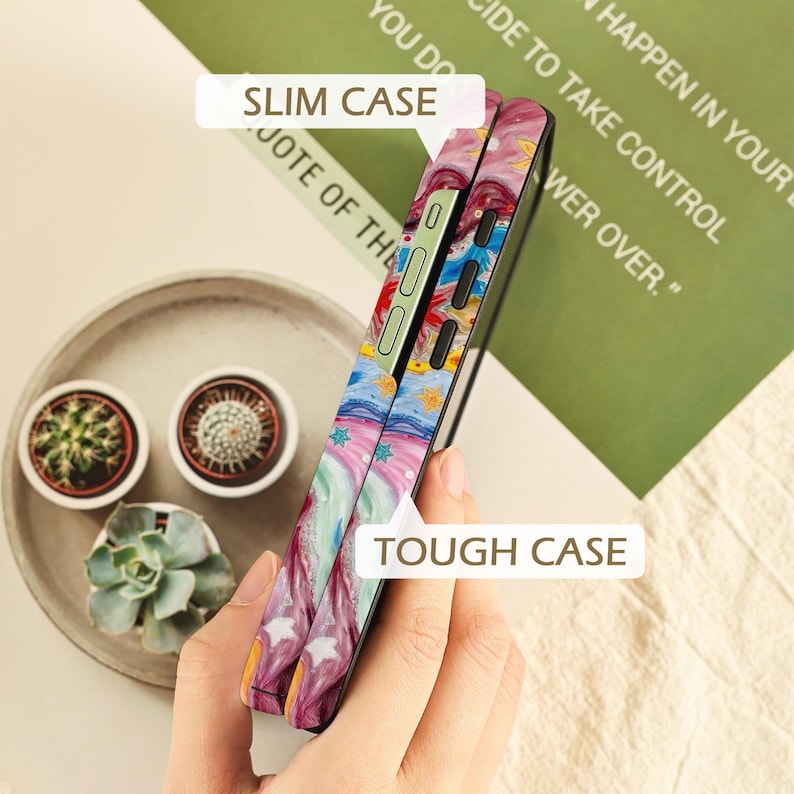 May include: Two phone cases shown side-by-side, one labeled SLIM CASE and the other TOUGH CASE. Both feature a vibrant, swirling abstract pattern in shades of pink, blue, and yellow with star accents. The slim case has a single layer, while the tough case appears thicker with a dual-layer construction, both displaying precise cutouts for buttons.