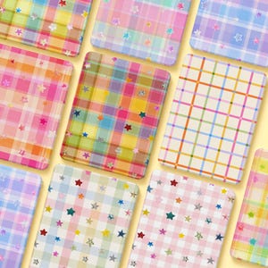 May include: A collection of rectangular cards featuring various plaid and checkered patterns in pastel and vibrant colors. Each card is decorated with small, scattered star shapes in contrasting hues, including red, blue, yellow, and silver glitter finishes.