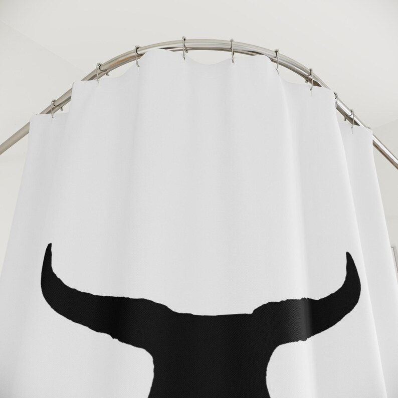 May include: White shower curtain with a black silhouette of a bull's head.