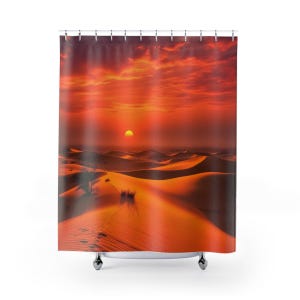 May include: A shower curtain featuring a desert landscape at sunset. The image shows orange sand dunes under a fiery red sky with the sun setting in the distance. The curtain is designed to hang from a rod.