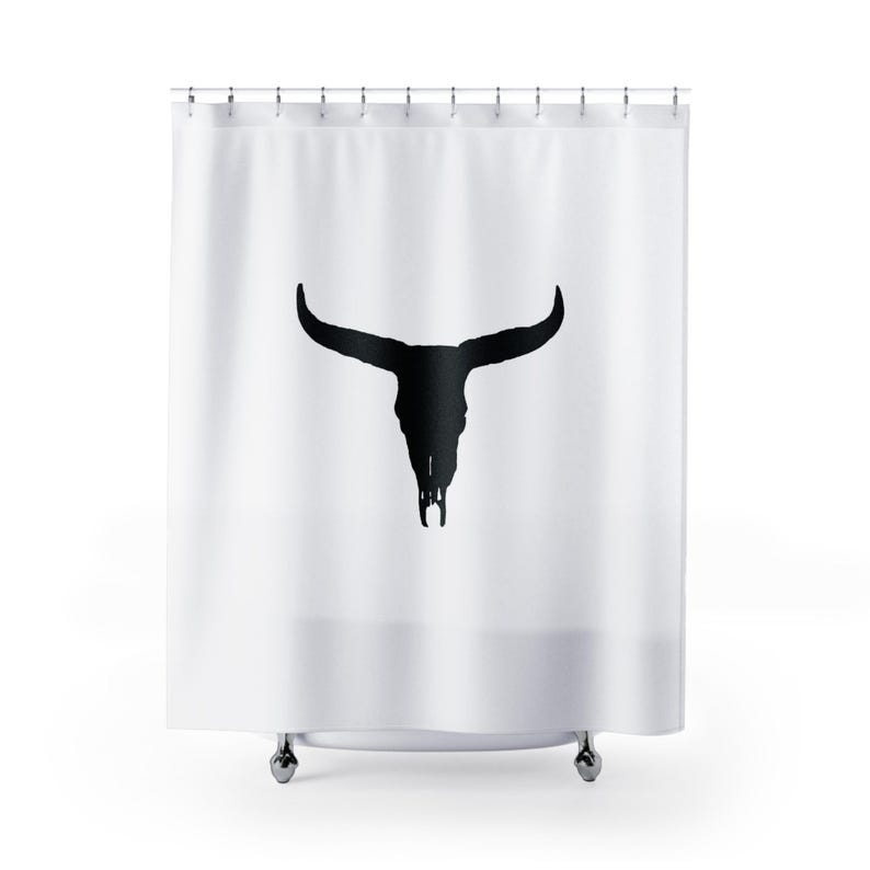 May include: White shower curtain with a black silhouette of a bull skull.