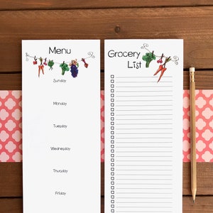 Op de afbeelding: Een witte set menu- en boodschappenlijstnotitieblokken met een houten potlood. Het menunotitieblok heeft het woord "Menu" bovenaan, met de dagen van de week eronder. Het boodschappenlijstnotitieblok heeft het woord "Boodschappenlijst" bovenaan, met selectievakjes.