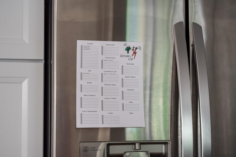 May include: A white grocery list with a colourful logo is attached to a stainless steel refrigerator. The list is divided into sections for various grocery items, such as produce, dairy, and frozen foods. The words "Grocery List" are at the top.
