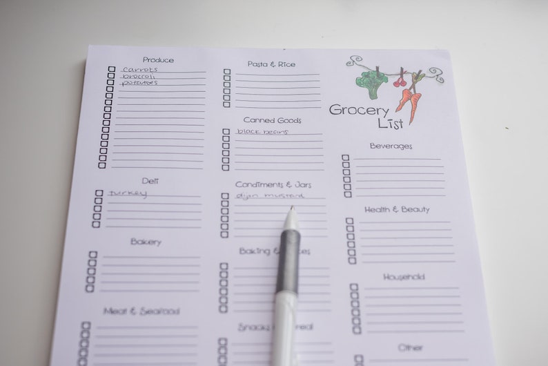 May include: A white grocery list with sections for produce, pasta, canned goods, and more. The list includes handwritten items like carrots, broccoli, and black beans. A pen points to the "Condiments & Jars" section. The words "Grocery List" are at the top.