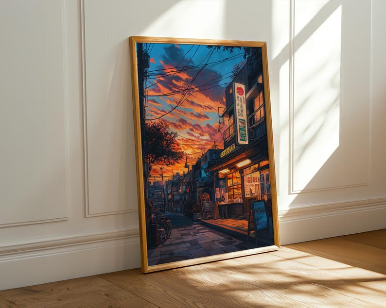 Puede incluir: Una pintura enmarcada que representa una escena callejera en Jap&oacute;n. La calle est&aacute; bordeada de edificios, algunos de los cuales tienen letreros en japon&eacute;s. El cielo es de un naranja y rosa vibrantes, y hay nubes en el cielo. La pintura est&aacute; en un marco de madera.