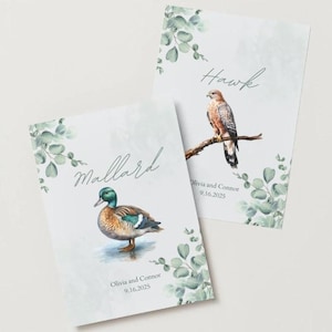 Könnte beinhalten: Zwei Karten mit Aquarellillustrationen einer Stockente und eines Falken. Die Karten haben Eukalyptusblatt-Akzente und die Namen "Mallard" und "Hawk" in Schreibschrift. Das Datum "9.16.2025" ist ebenfalls auf den Karten aufgedruckt.