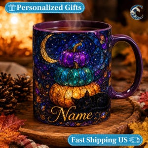 May include: A purple ceramic mug featuring a stained-glass style design of three stacked pumpkins in purple, teal, and orange. A black cat rests at the base of the pumpkins under a crescent moon. The word Name is printed in gold script at the bottom.