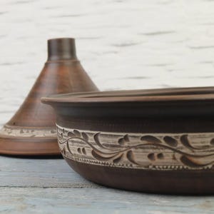 Side view of carved terracotta tagine pot