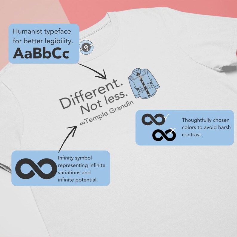 Pu&ograve; includere: Una t-shirt bianca con un design grafico che riporta il testo Different. Not less. e il nome Temple Grandin. Il disegno include una piccola illustrazione di una camicia azzurra abbottonata e un simbolo dell'infinito in inchiostro grigio scuro.