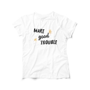 May include: White t-shirt with black text that reads "MAKE good TROUBLE" with gold star accents.