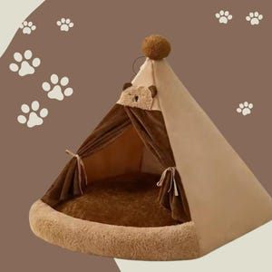 May include: A brown and beige pet teepee tent with a plush bear face on the front. The teepee has a soft, brown, furry lining and a brown, plush cushion inside.