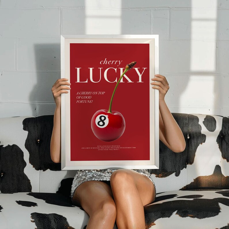 K&ouml;nnte beinhalten: Ein rotes und wei&szlig;es Poster mit dem Text "cherry lucky" und einer Kirsche mit einer Acht-Ball-Kugel darauf. Der Text unter der Kirsche lautet "A cherry on top of good fortune!"